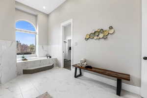 Full bathroom featuring a bath, light marble finish flooring, and recessed lighting
