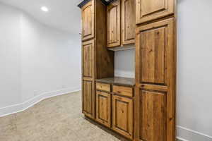Kitchen with recessed lighting, dark stone counters, and brown cabinetry