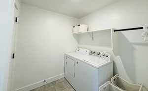 Laundry room with light tile patterned flooring and washing machine and dryer
