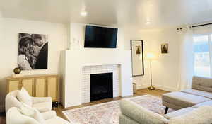 Living area featuring a fireplace, wood finished floors, and recessed lighting