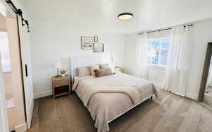 Carpeted bedroom with a barn door and a textured ceiling