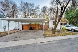 View of front of house featuring asphalt driveway and a detached carport