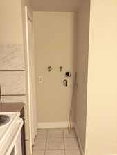 Laundry room with hookup for a washing machine and light tile patterned floors