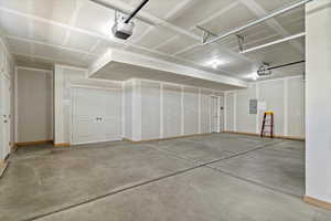 Garage featuring a garage door opener and electric panel