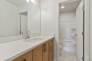 Bathroom featuring vanity, washtub / shower combination, light tile patterned floors, and recessed lighting