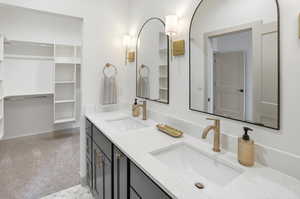 Full bathroom with double vanity and a spacious closet