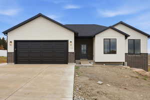 View of front of house featuring brick siding, concrete driveway, and a garage