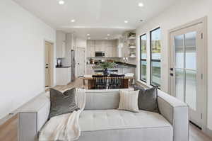 Living area with light wood-style flooring and recessed lighting