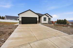 View of front facade featuring brick siding, concrete driveway, and a garage
