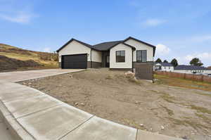 View of front of property with brick siding, driveway, and a garage