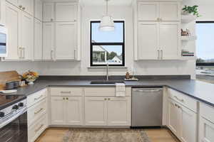 Kitchen featuring open shelves, appliances with stainless steel finishes, healthy amount of natural light, and white cabinetry