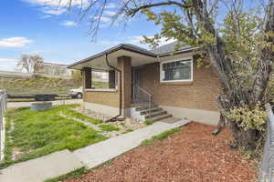 View of front of property with brick siding and roof with shingles