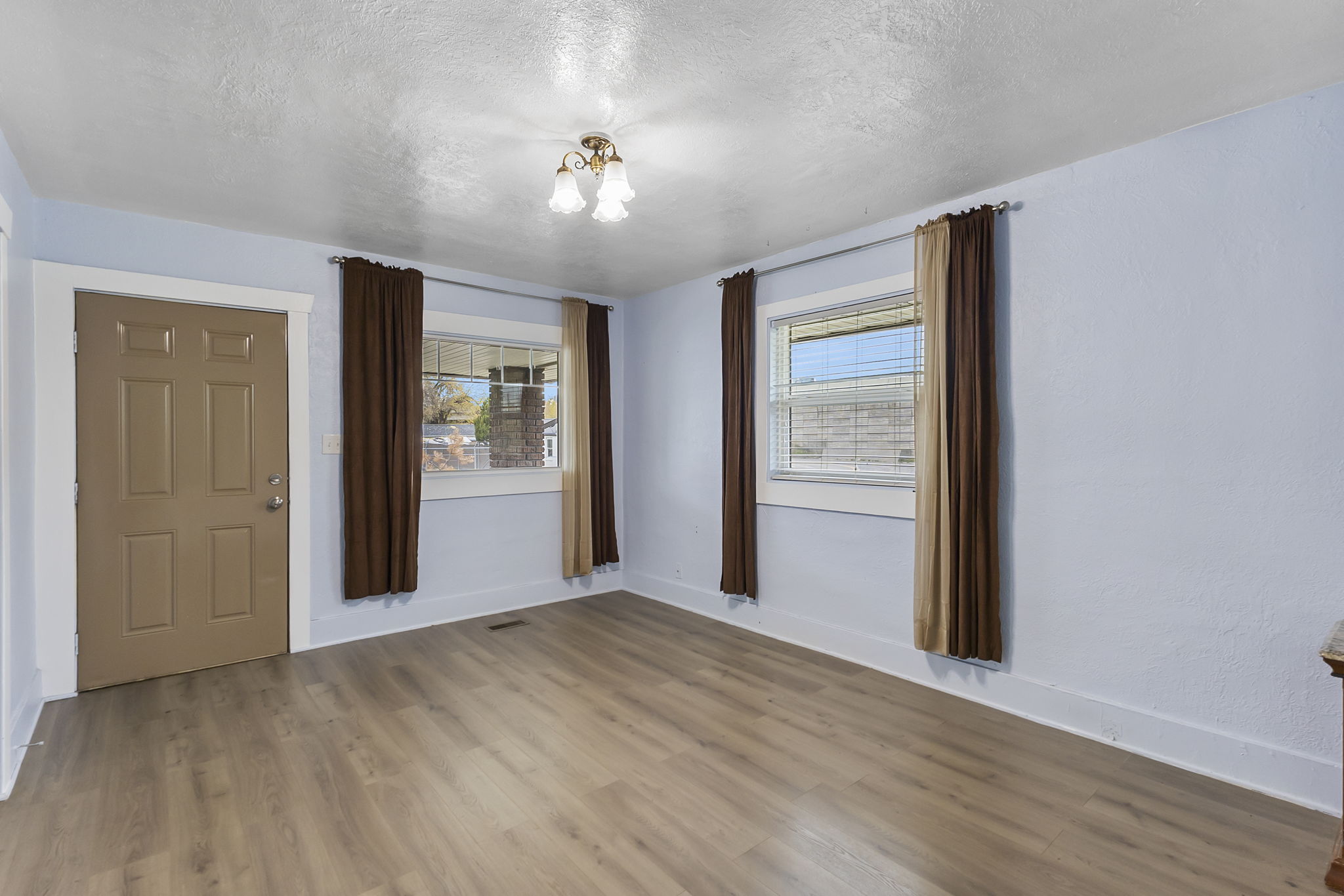 Spare room featuring a textured ceiling, wood finished floors, and a chandelier