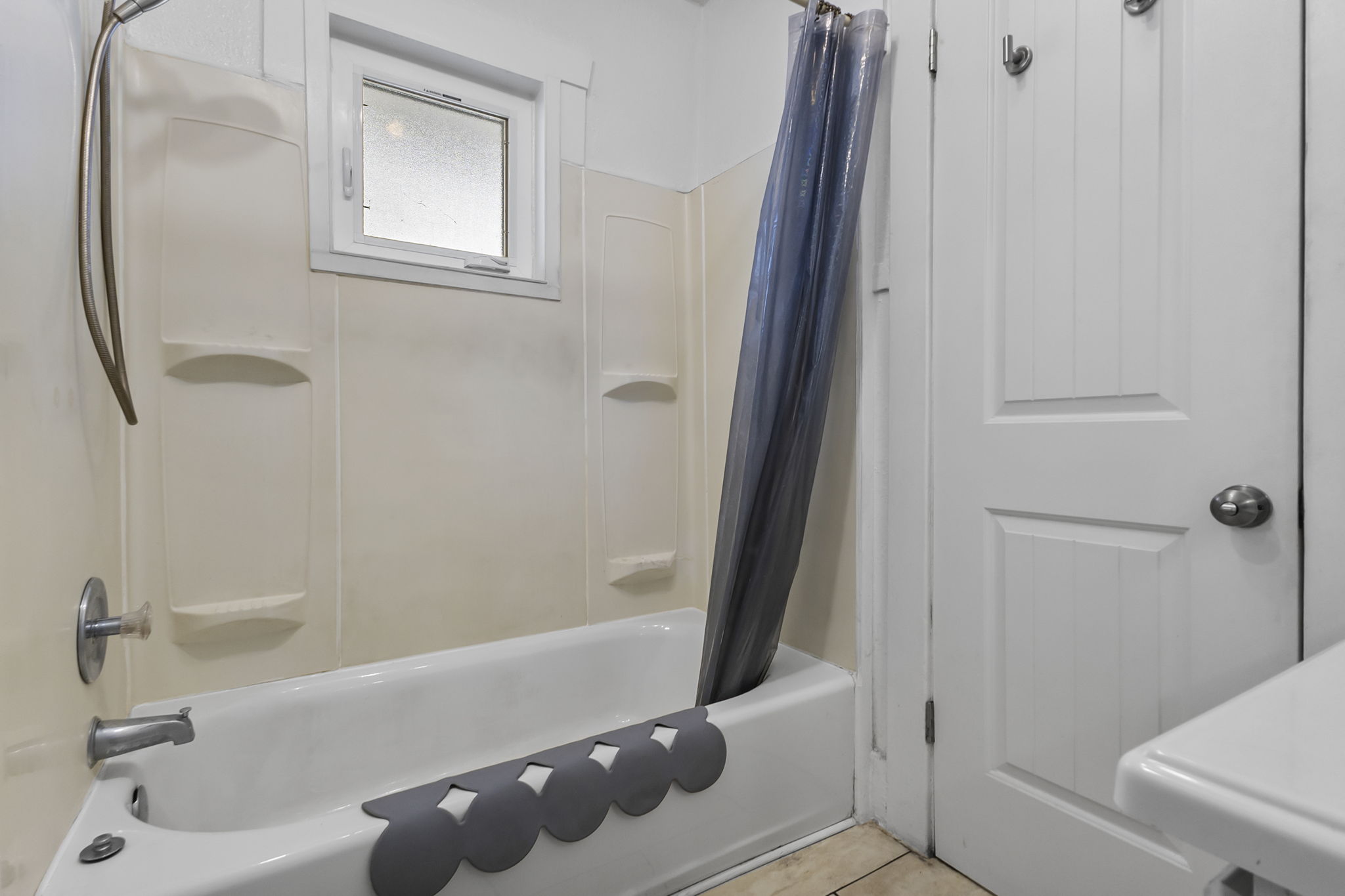 Bathroom featuring shower / bathtub combination with curtain and light tile patterned floors