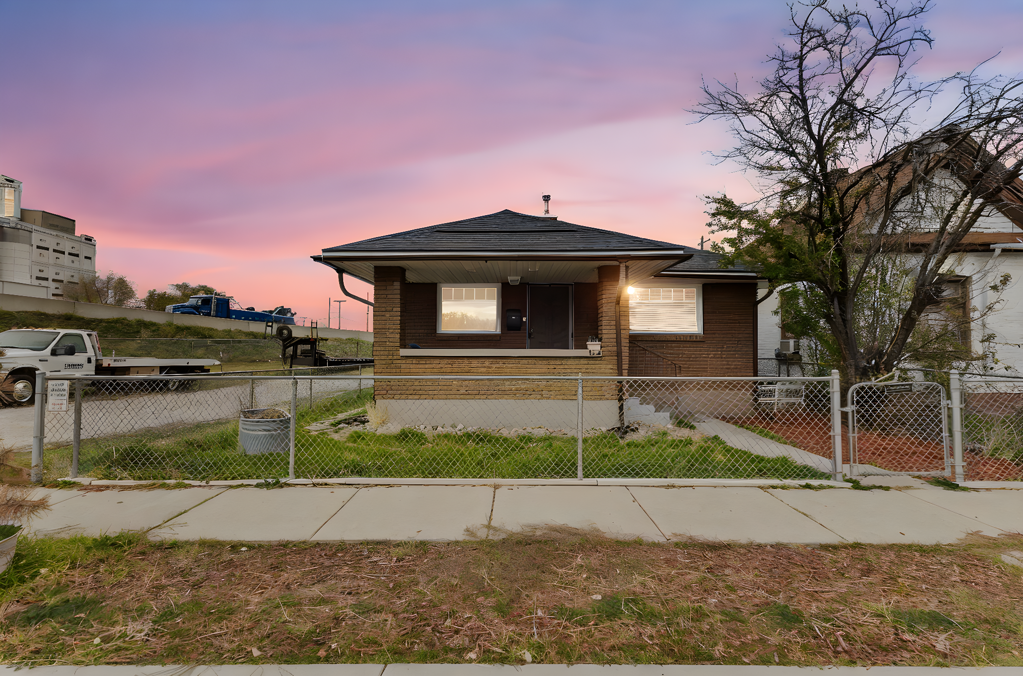 Bungalow-style house with a gate, a fenced front yard, brick siding, and covered porch