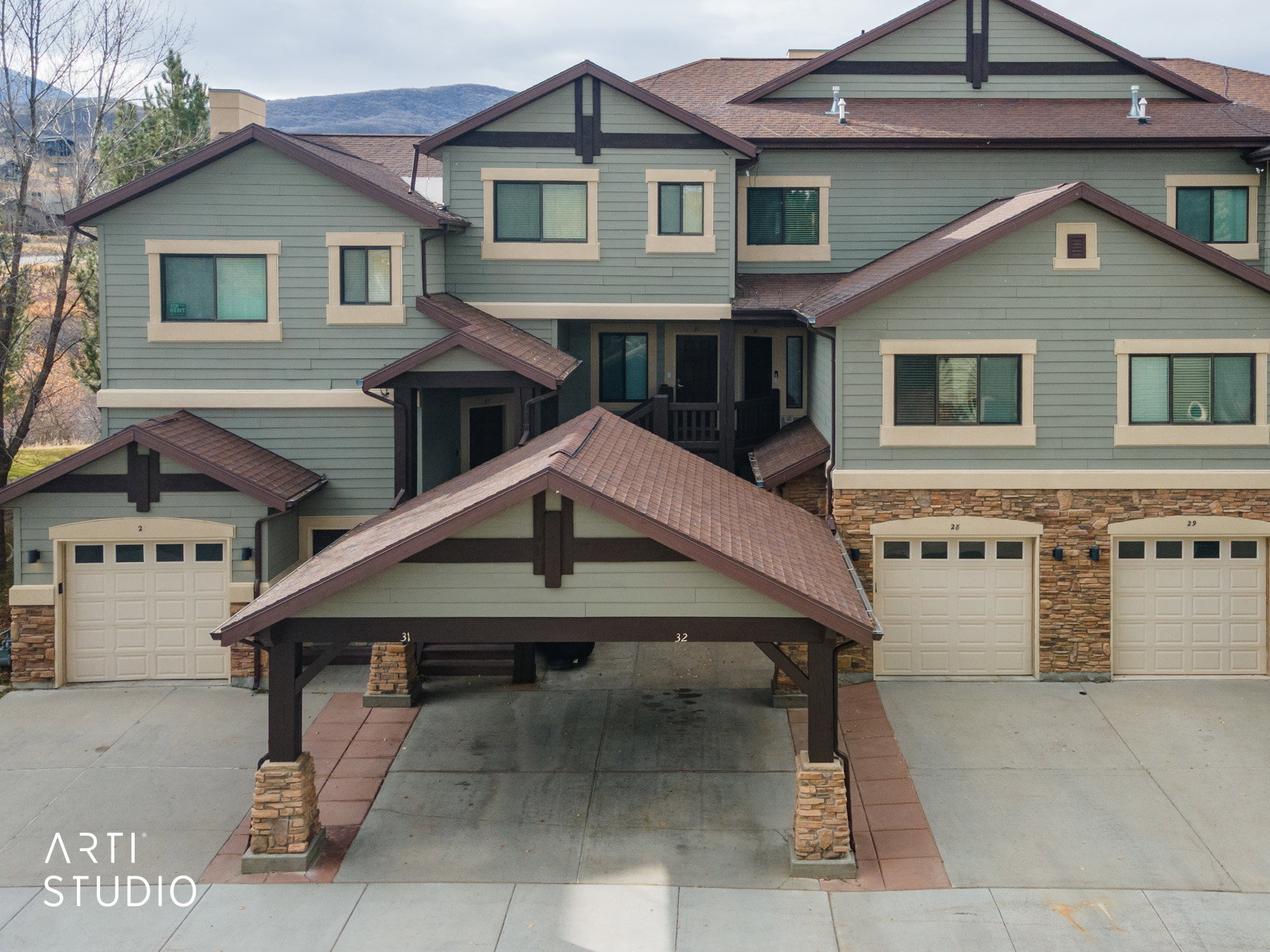 Craftsman house with a garage, stone siding, concrete driveway, and roof with shingles