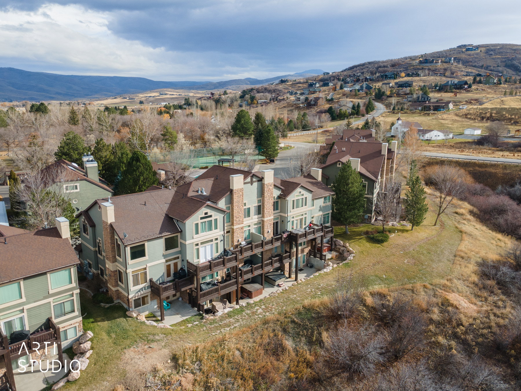 Aerial view of property's location with nearby suburban area and a mountainous background