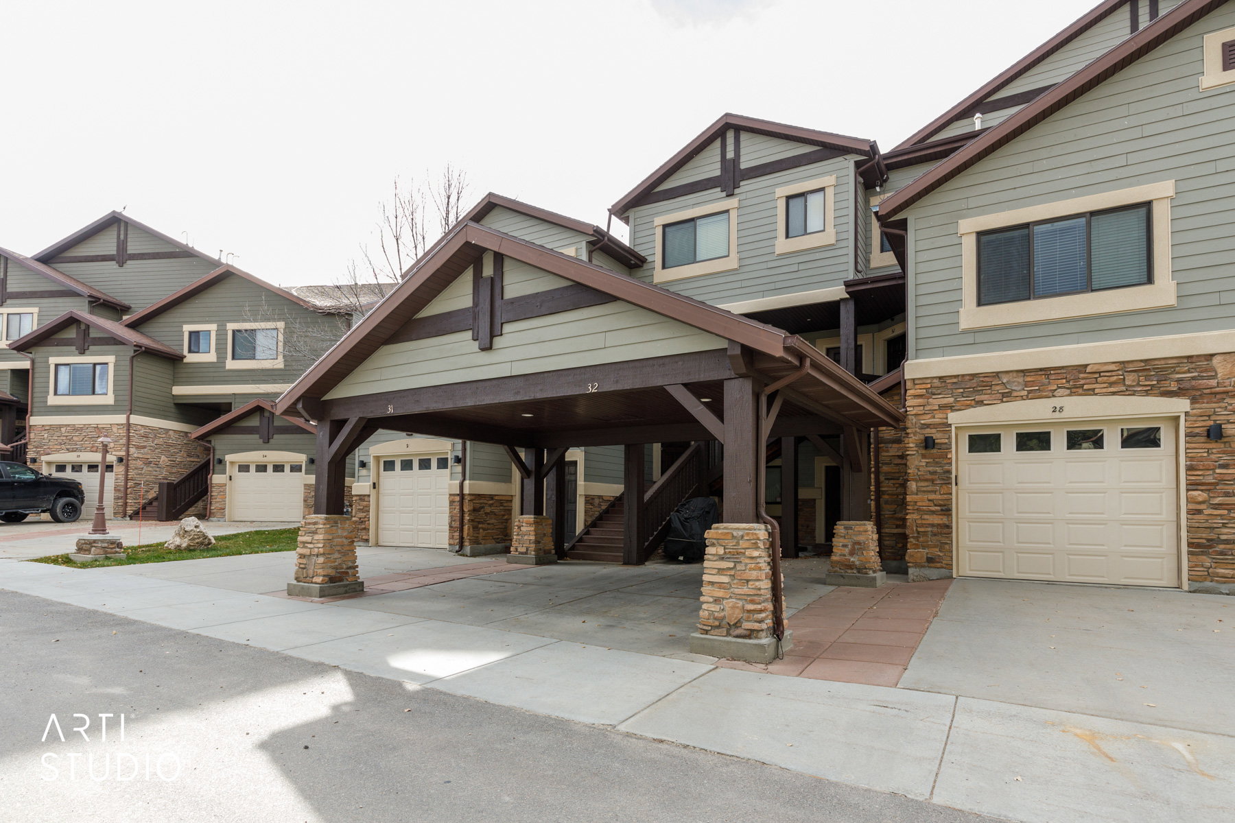 Craftsman-style home with stone siding and driveway