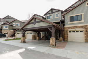 Craftsman-style home with stone siding and driveway