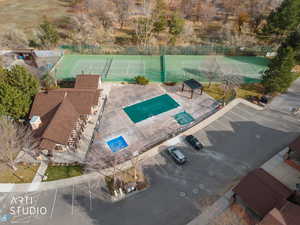 Drone / aerial view of a pool and tennis courts