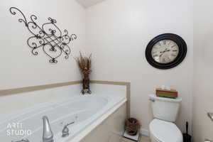 Full bathroom featuring a tub with jets and toilet