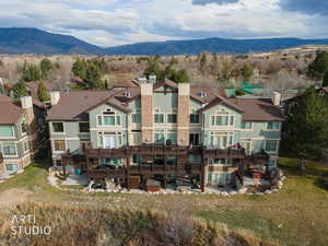 Rear view of house with a patio area, a mountain view, and a yard