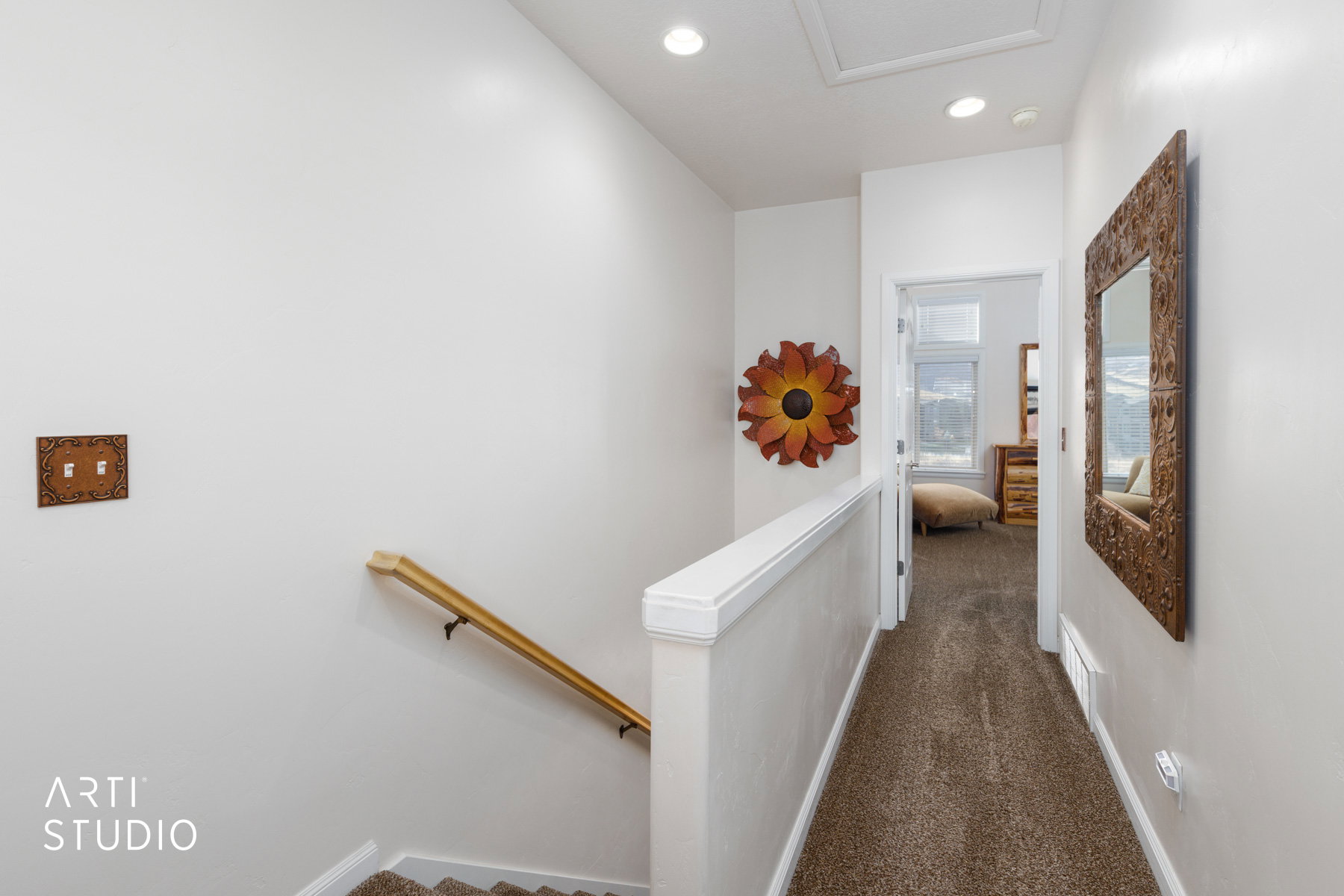Hallway with dark colored carpet and recessed lighting