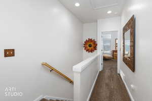 Hallway with dark colored carpet and recessed lighting