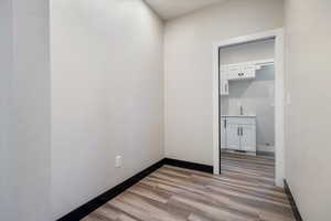 Unfurnished room with light wood-style floors and baseboards