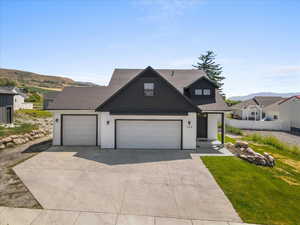 Modern inspired farmhouse with concrete driveway, roof with shingles, a garage, and a mountain view