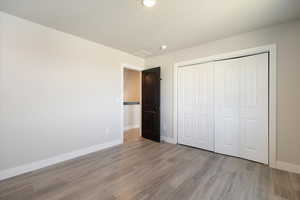 Unfurnished bedroom with light wood-style floors and a closet