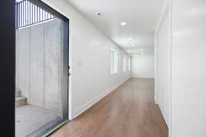 Corridor with wood finished floors and recessed lighting