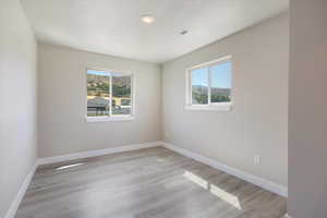Empty room featuring baseboards and light wood-style flooring