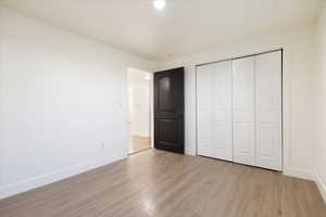 Unfurnished bedroom with light wood-style floors, a closet, and recessed lighting