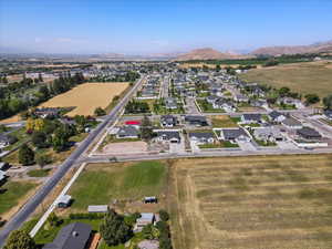 Aerial view of property and surrounding area with a mountain backdrop and nearby suburban area