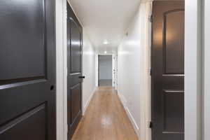 Hall with baseboards and light wood finished floors