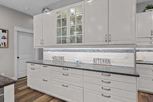 Kitchen featuring white cabinetry, Quartz counters, and glass insert cabinets