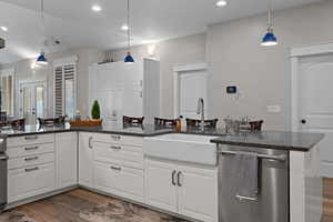 Kitchen with dishwasher, Quartz countertops, white cabinetry, hanging light fixtures, and recessed lighting