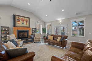 Living area with french doors, recessed lighting, plenty of natural light, lofted ceiling, and wood finished floors