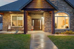 Entrance to property with stone siding and a yard