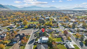Aerial overview of property's location with a mountainous background and nearby suburban area