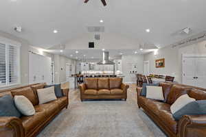 Large, open Living room with lofted ceiling, wood finished floors, recessed lighting, and a ceiling fan