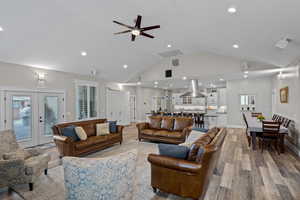 Living area featuring french doors, wood finished floors, a ceiling fan, high vaulted ceiling, and recessed lighting