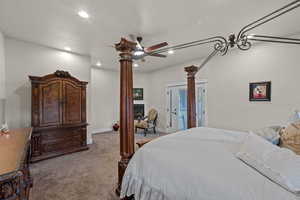 Primary Bedroom with carpet flooring, recessed lighting, access to heated patio, ceiling fan, and a fireplace