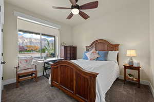 Bedroom featuring dark carpet,, large windows letting in lots of natural sunlight, and a ceiling fan
