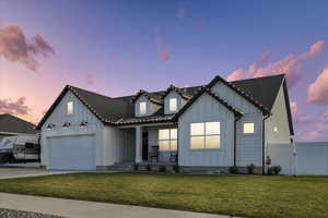 Modern farmhouse style home featuring covered porch, a gate, board and batten siding, a front yard, and concrete driveway