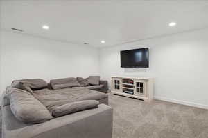 Living room with light colored carpet and recessed lighting
