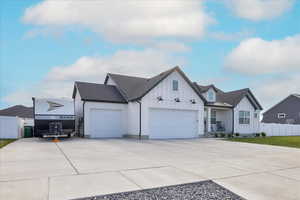 Modern farmhouse featuring board and batten siding, concrete driveway, a garage, and a porch