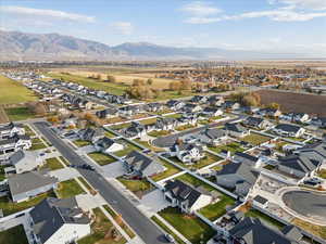Aerial view of property and surrounding area featuring nearby suburban area and mountains