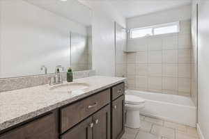 Bathroom featuring vanity, light tile patterned floors, and tub / shower combination